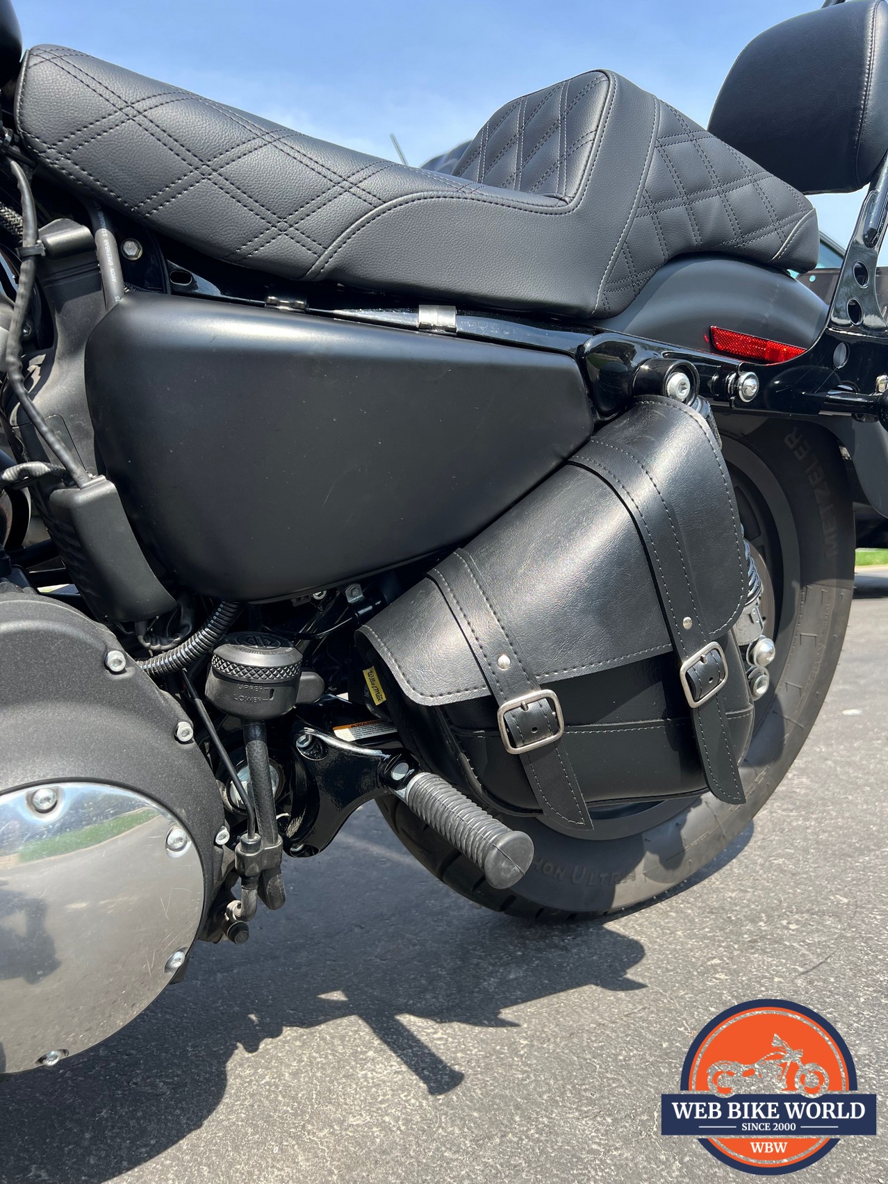 Swingarm bag mounted to the side of a motorcycle near the footpeg