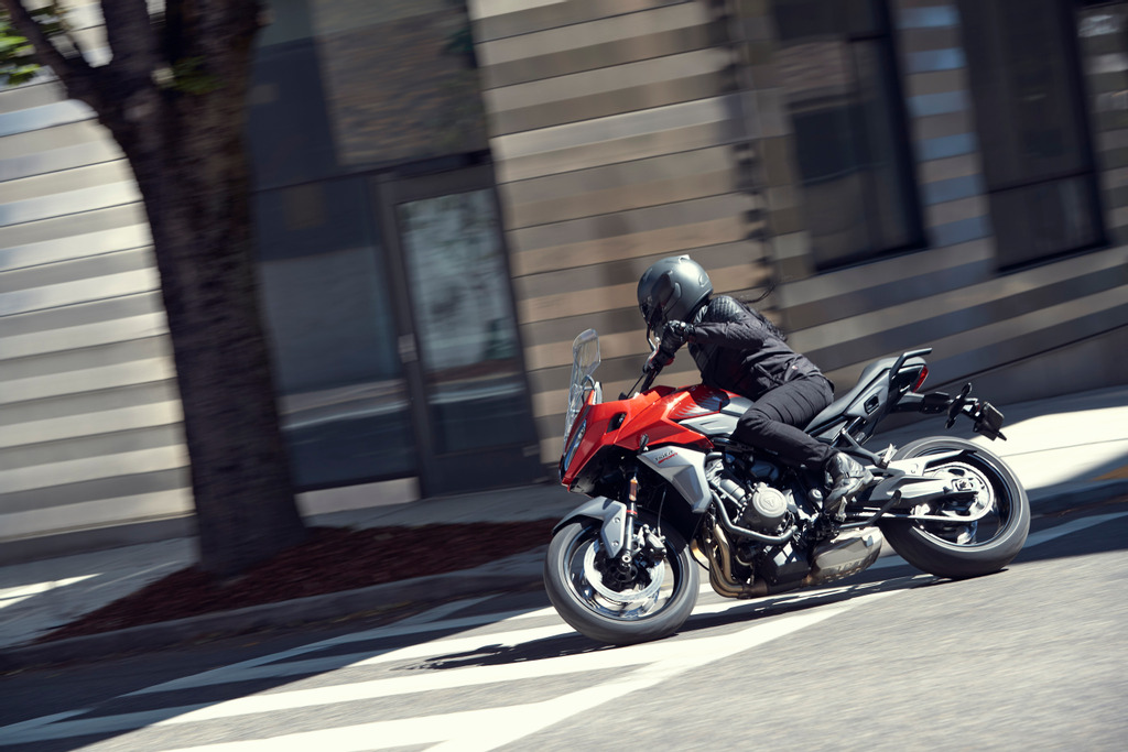 A side view of a motorcyclist on a bike.