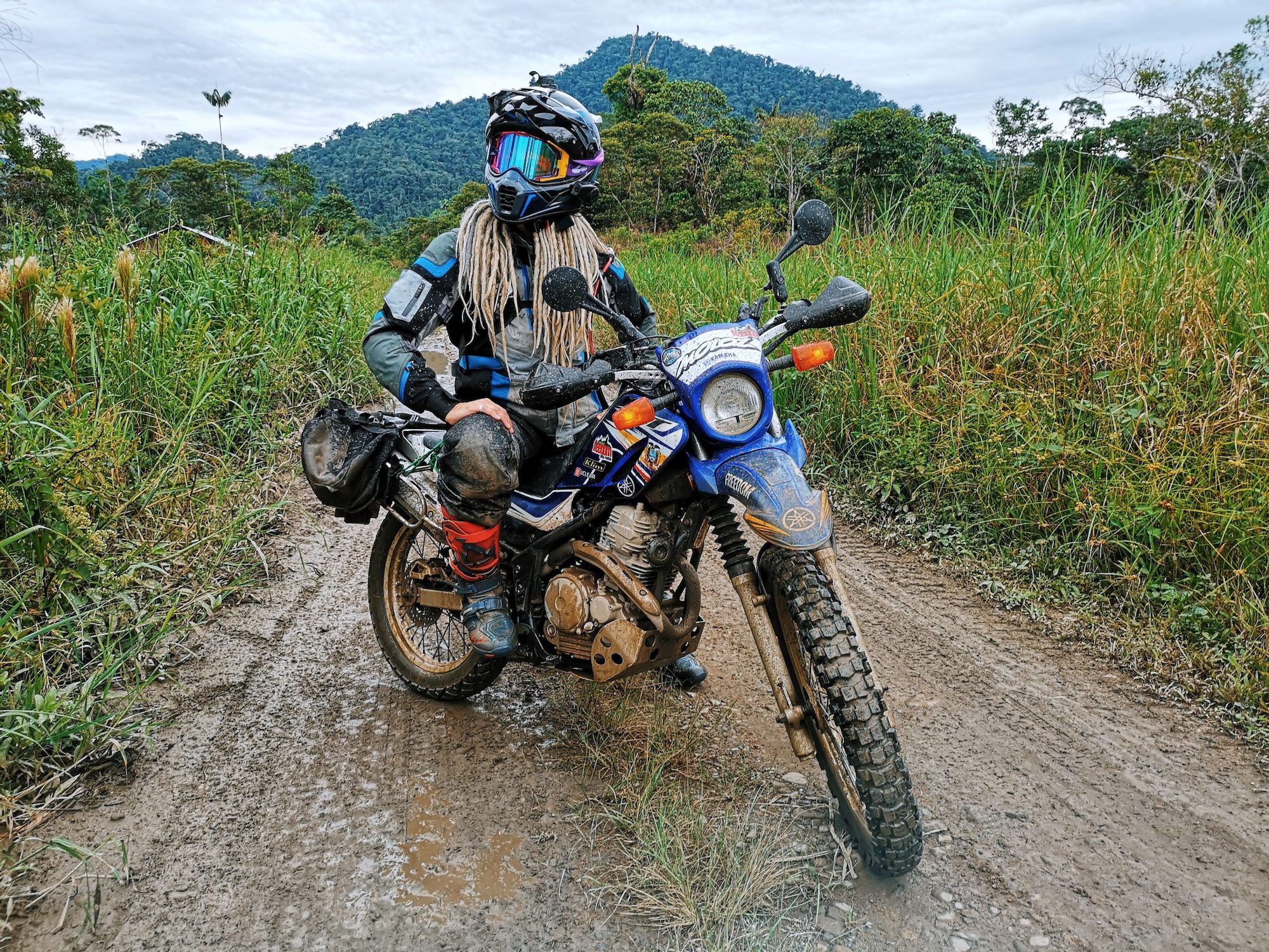 A female motorcyclist enjoying a pretty day int eh mud, on her machine of choice. Media sourced from Adventure Bound.