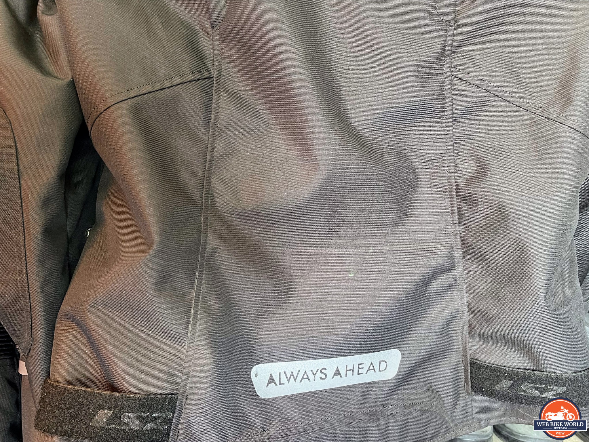 Velcro straps and reflective branding on the lower back of the jacket