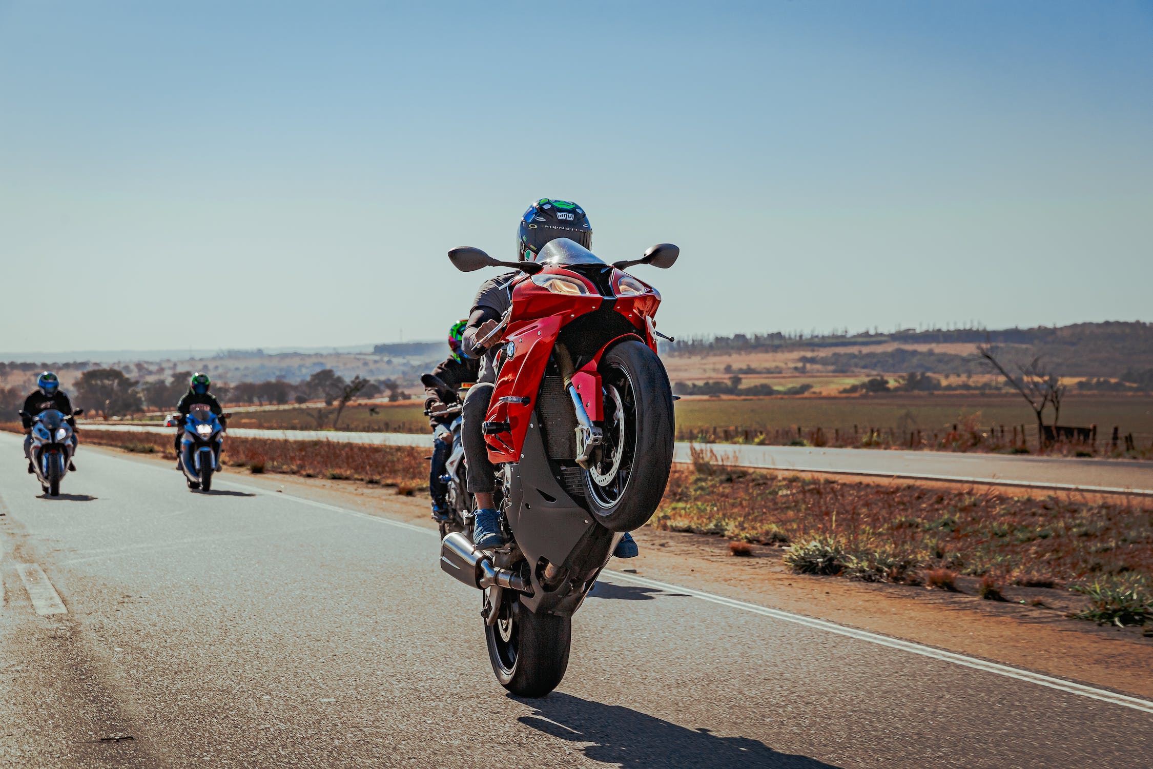A motorcyclists performs a wheelie on a motorcycle