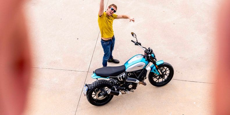 A model next to a Ducati Scrambler. Media sourced from Ducati.