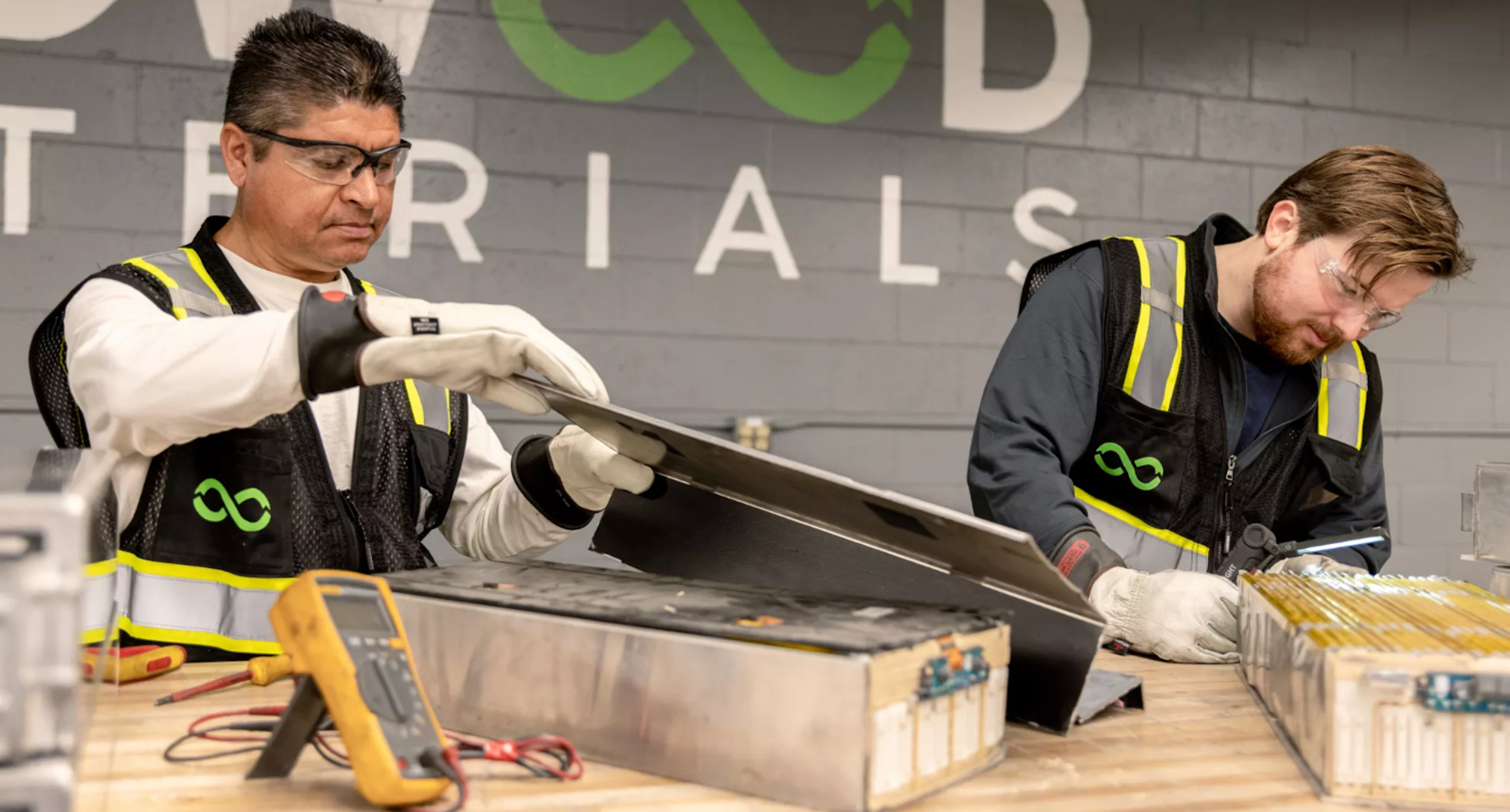 A pair of workers dismantling an EV battery. Media sourced from CleanTechnica. 