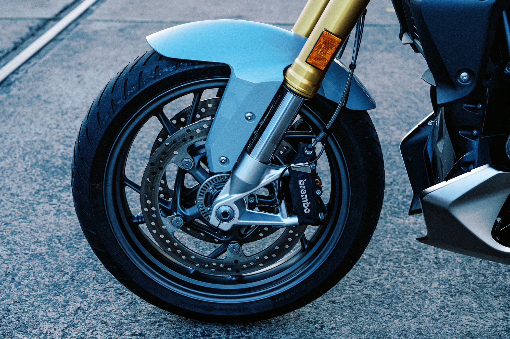 a detail photo of a 2023 BMW R 1250 R motorcycle at dusk in an old train carriage works