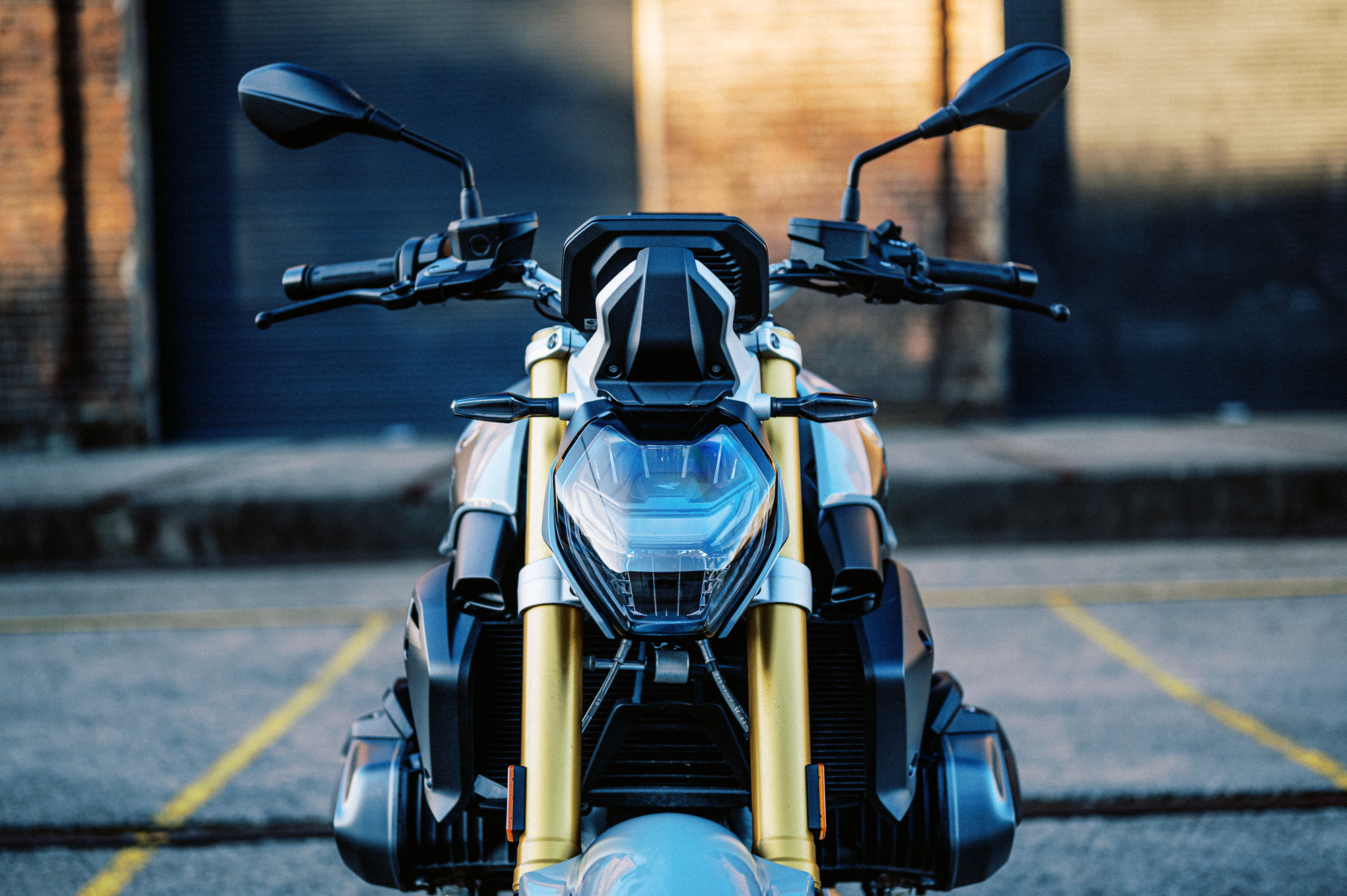 a detail photo of a 2023 BMW R 1250 R motorcycle at dusk in an old train carriage works