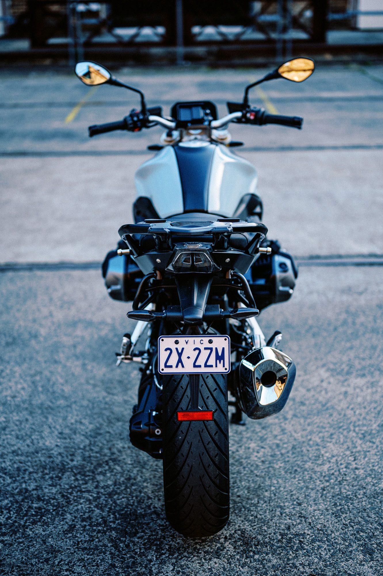 a detail photo of a 2023 BMW R 1250 R motorcycle at dusk in an old train carriage works
