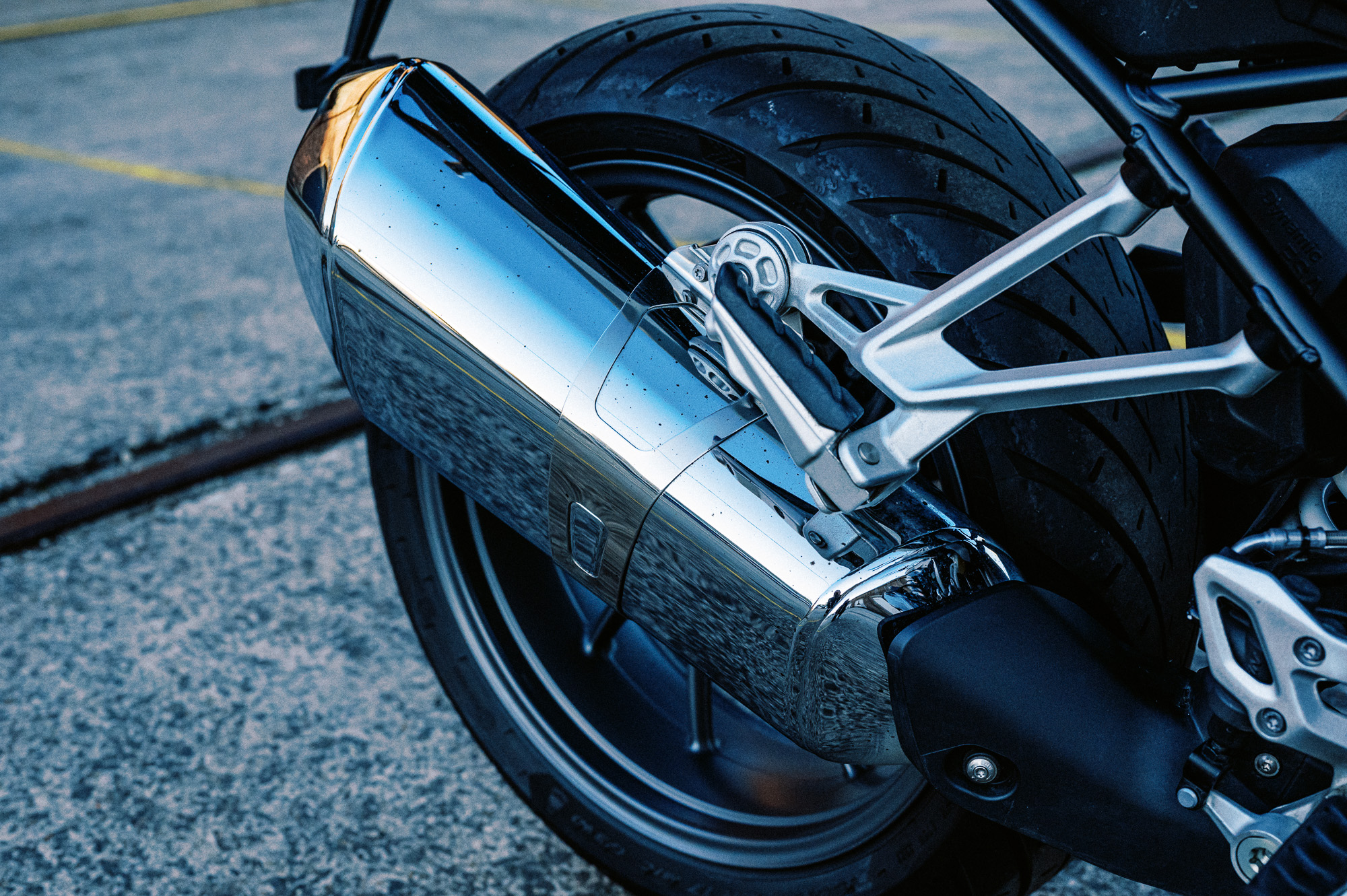 a detail photo of a 2023 BMW R 1250 R motorcycle at dusk in an old train carriage works