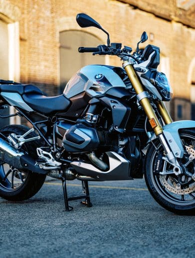 photo of a 2023 BMW R 1250 R motorcycle at dusk in an old train carrigeworks