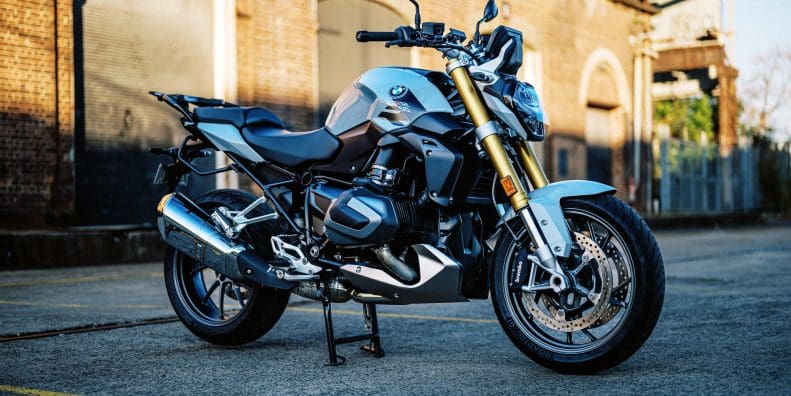 photo of a 2023 BMW R 1250 R motorcycle at dusk in an old train carrigeworks