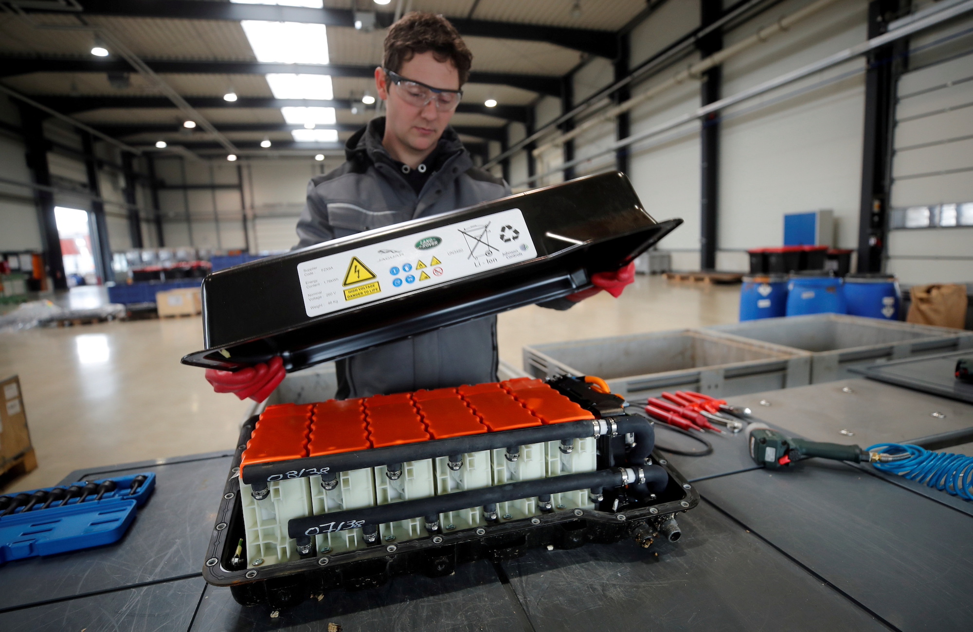 A worker opening a used lithium-ion battery. Media sourced from Reuters. 