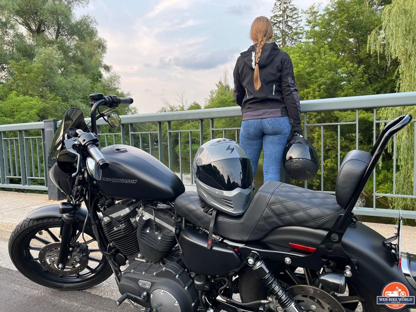 Harley Davidson Iron 883 with passenger standing behind it