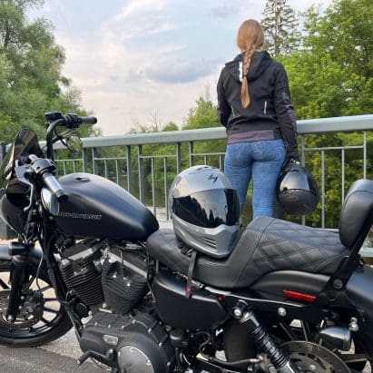 Harley Davidson Iron 883 with passenger standing behind it