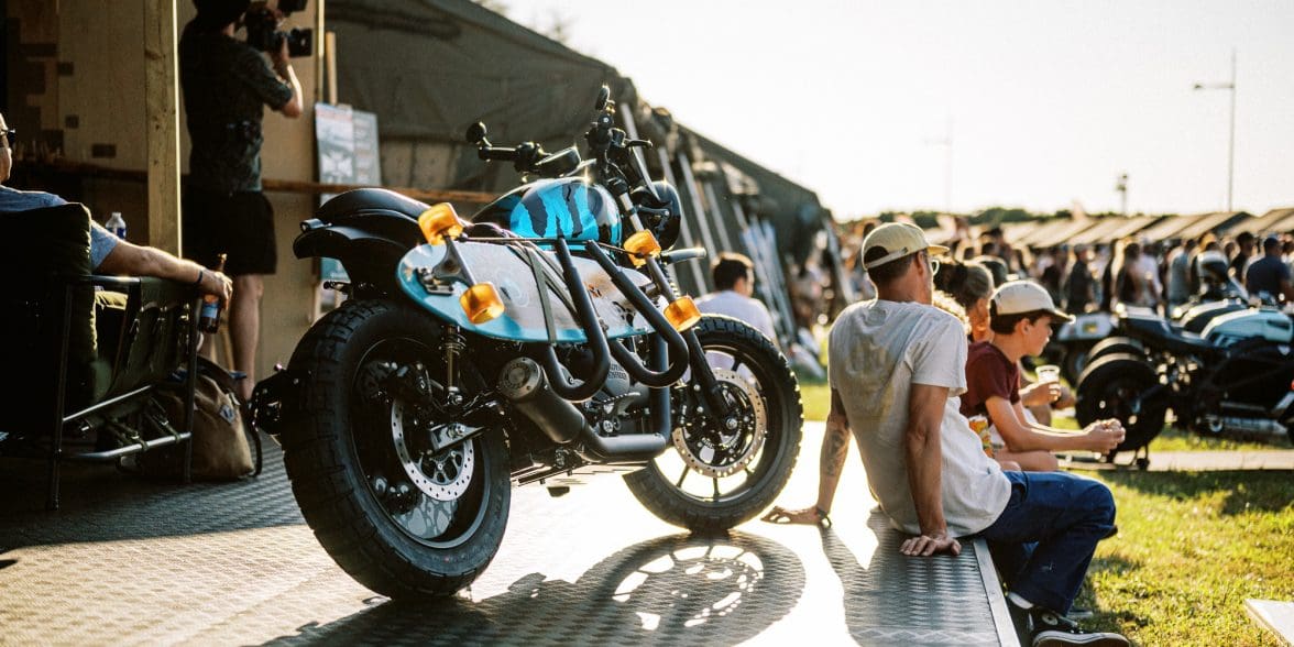 a motorcycle and visitors at the 2023 Wheels & Waves Bike Show in Biarritz, France