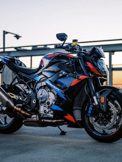 The 2023 BMW M 1000 R motorcycle on a rooftop car park at sunset