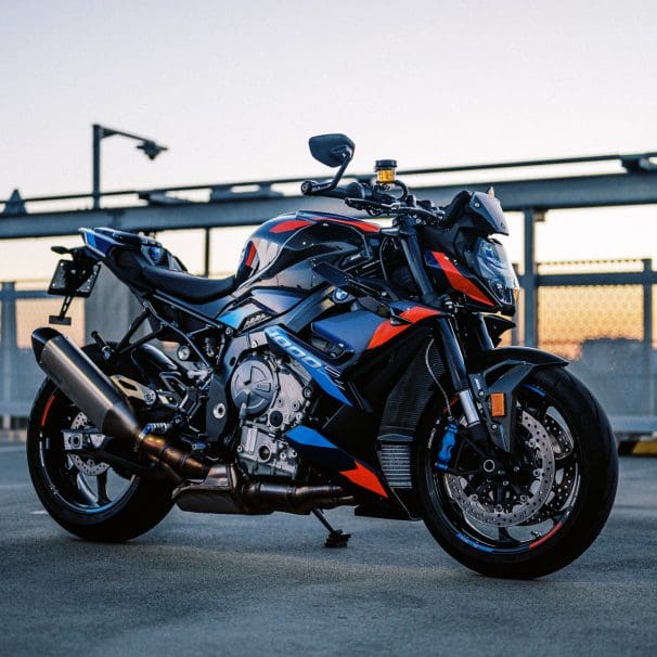 The 2023 BMW M 1000 R motorcycle on a rooftop car park at sunset