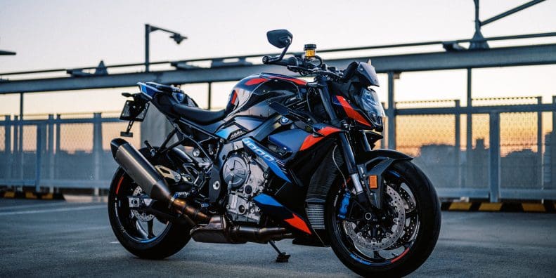 The 2023 BMW M 1000 R motorcycle on a rooftop car park at sunset