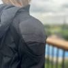 Ashley wearing the jacket inside out showcasing the shoulder armor pocket form the back view
