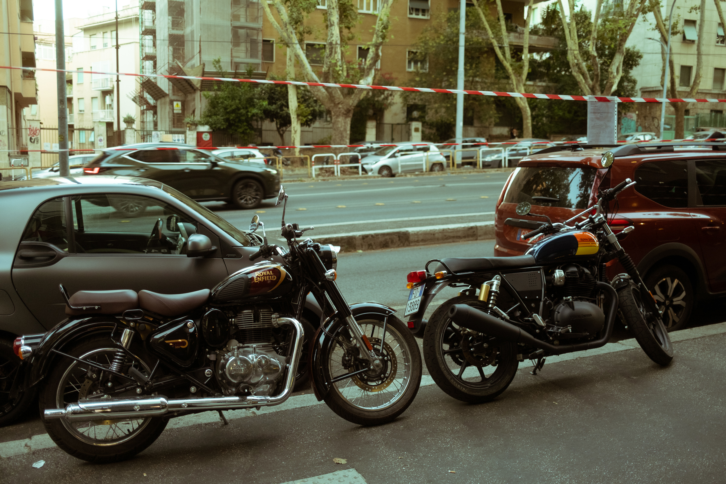 Two Royal Enfield motorcycles parked on a Rome street