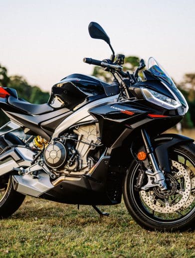 A 2023 Aprilia Tuono 660 Factory in a park at sunset.