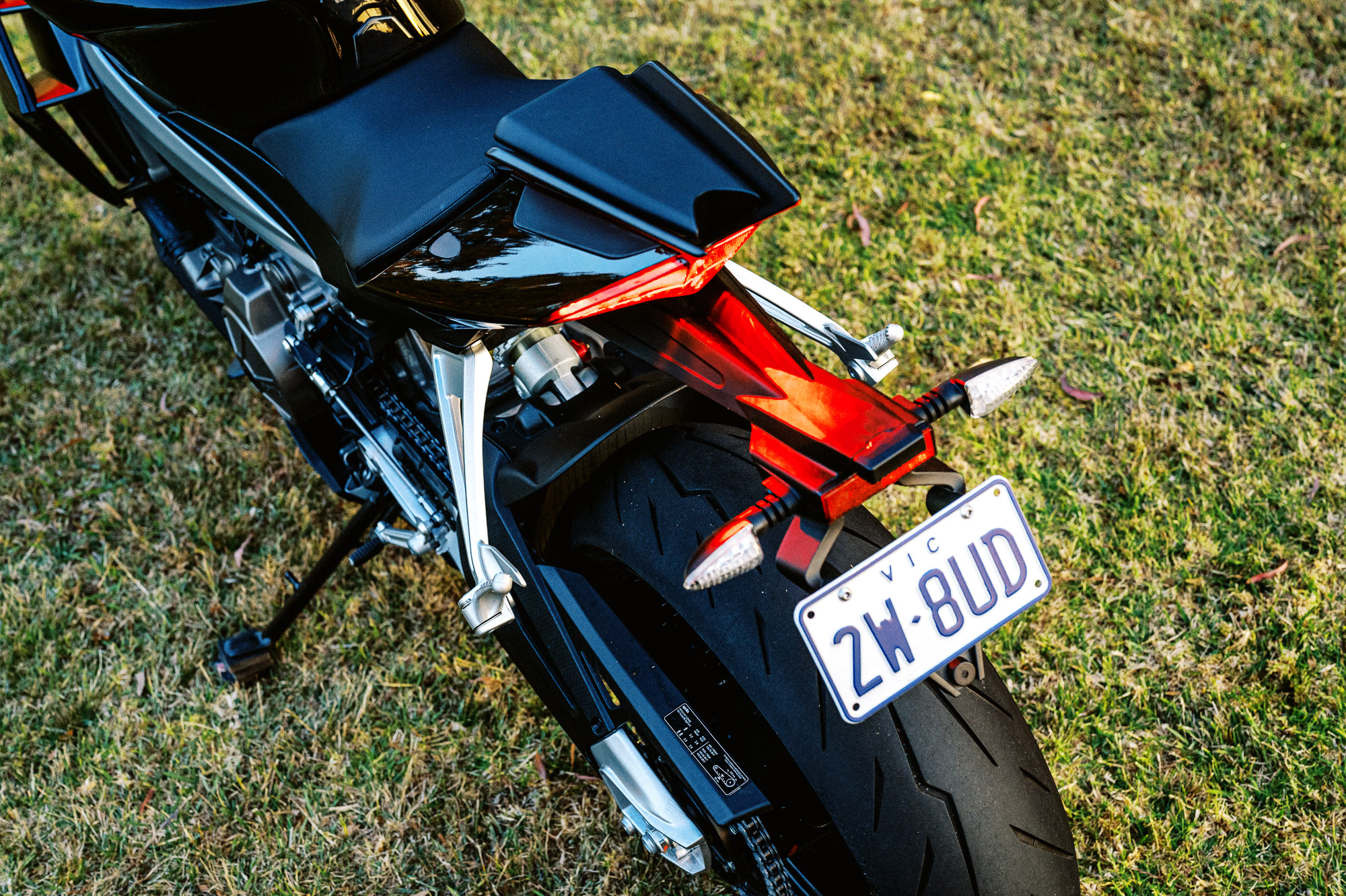 Detail shot of a 2023 Aprilia Tuono 660 Factory in a park at sunset