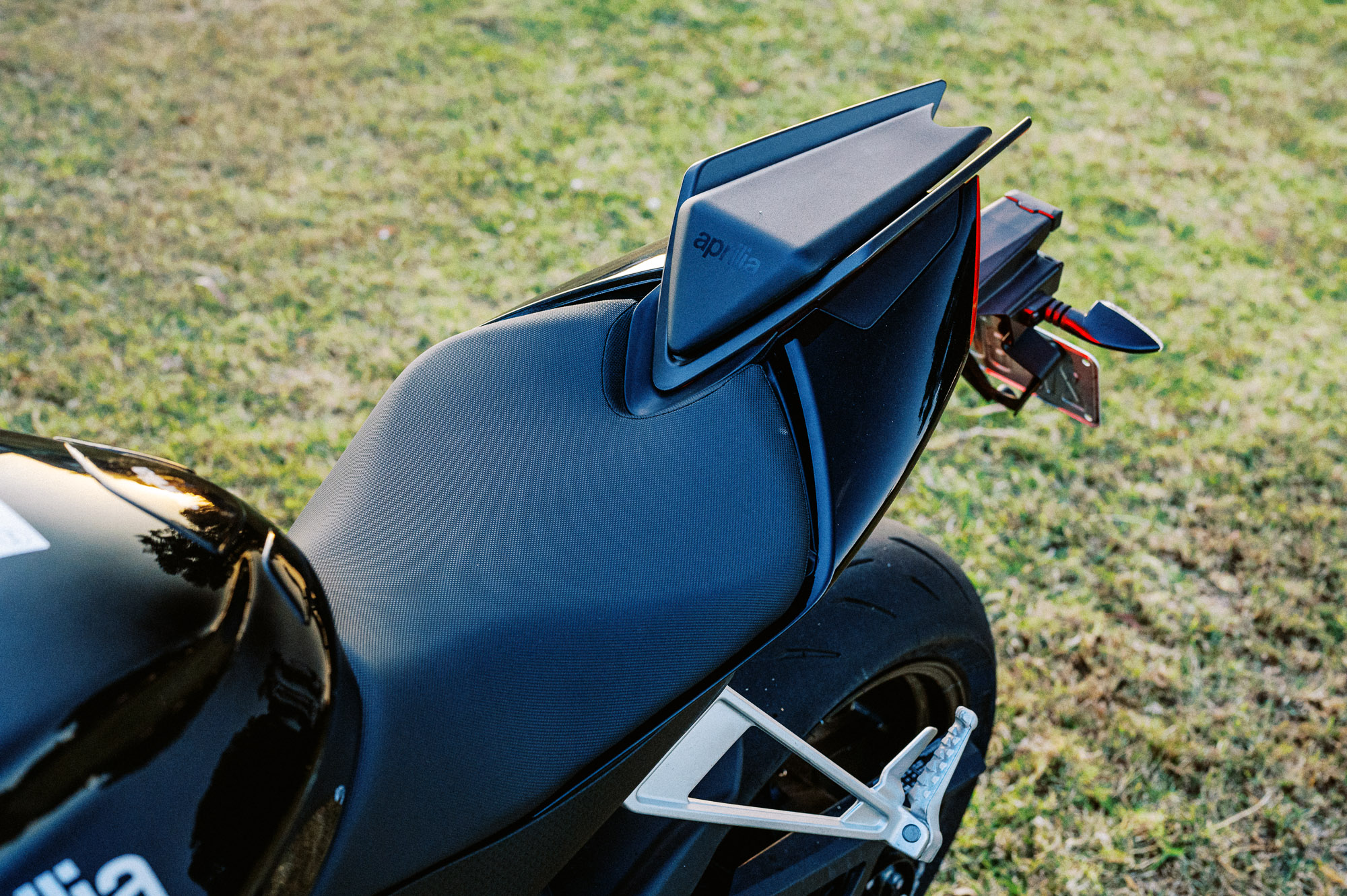 Detail shot of a 2023 Aprilia Tuono 660 Factory in a park at sunset