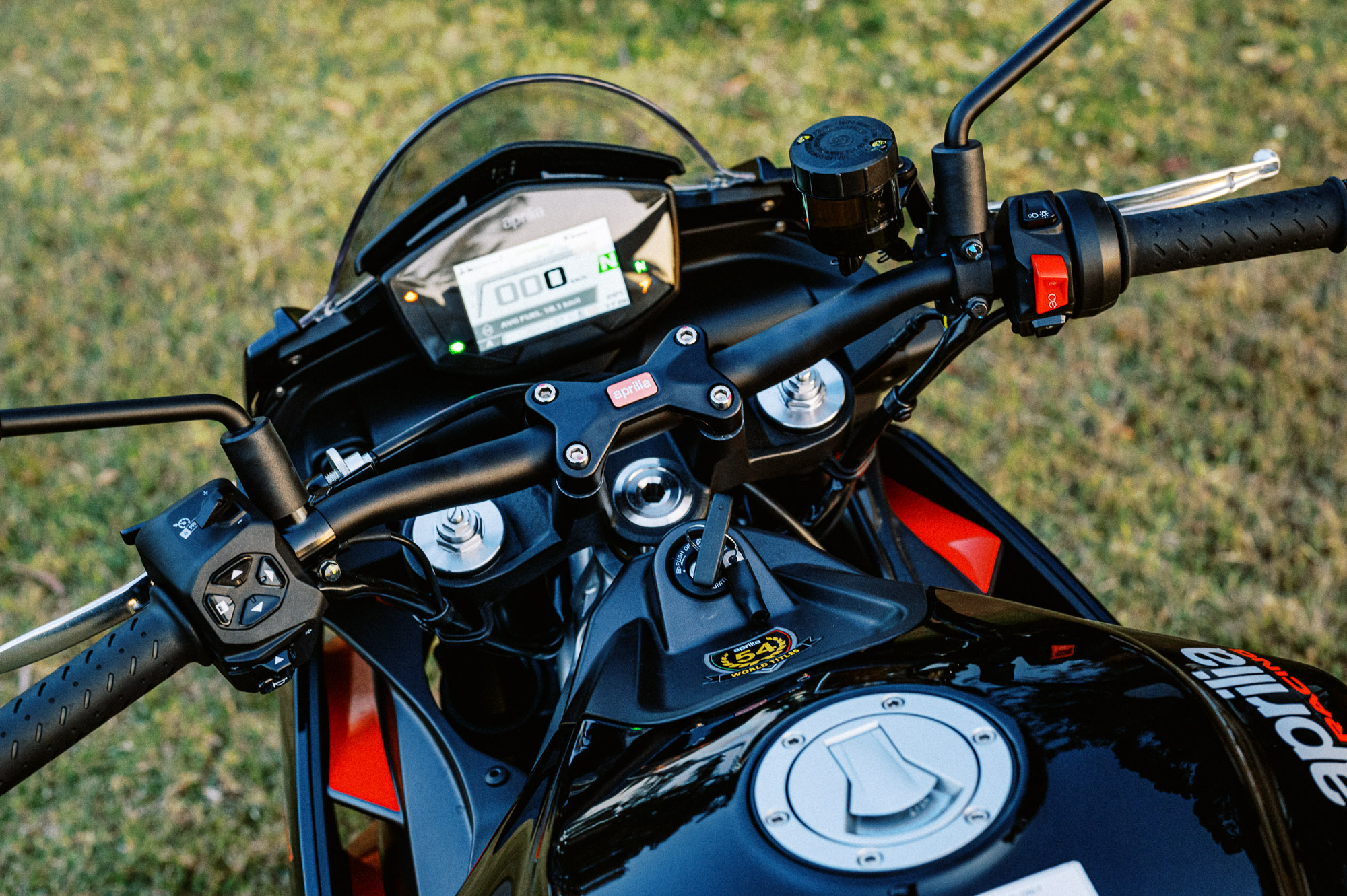 Detail shot of a 2023 Aprilia Tuono 660 Factory in a park at sunset