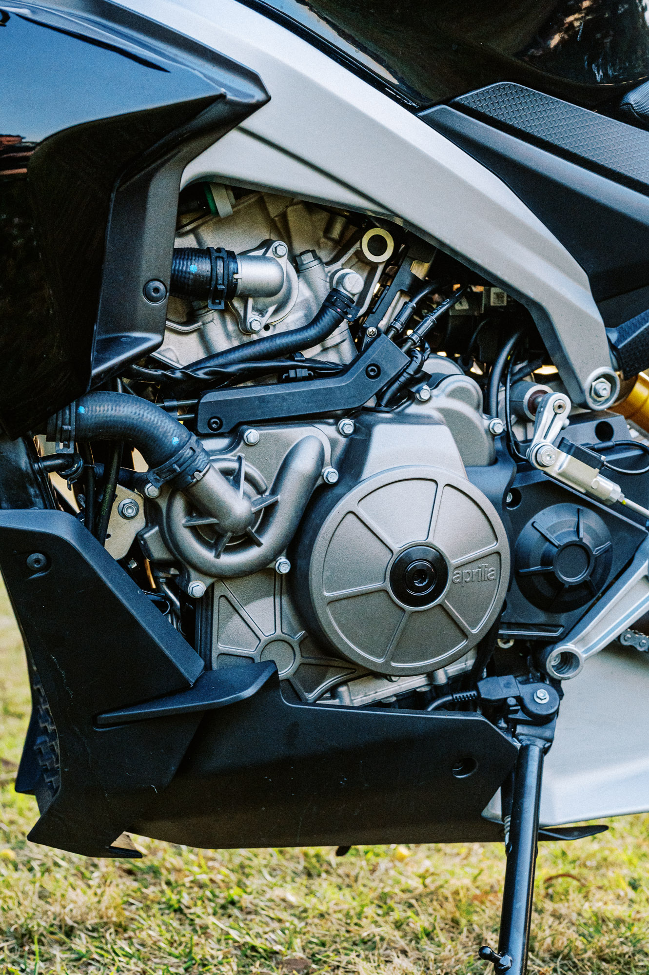 Detail shot of a 2023 Aprilia Tuono 660 Factory in a park at sunset