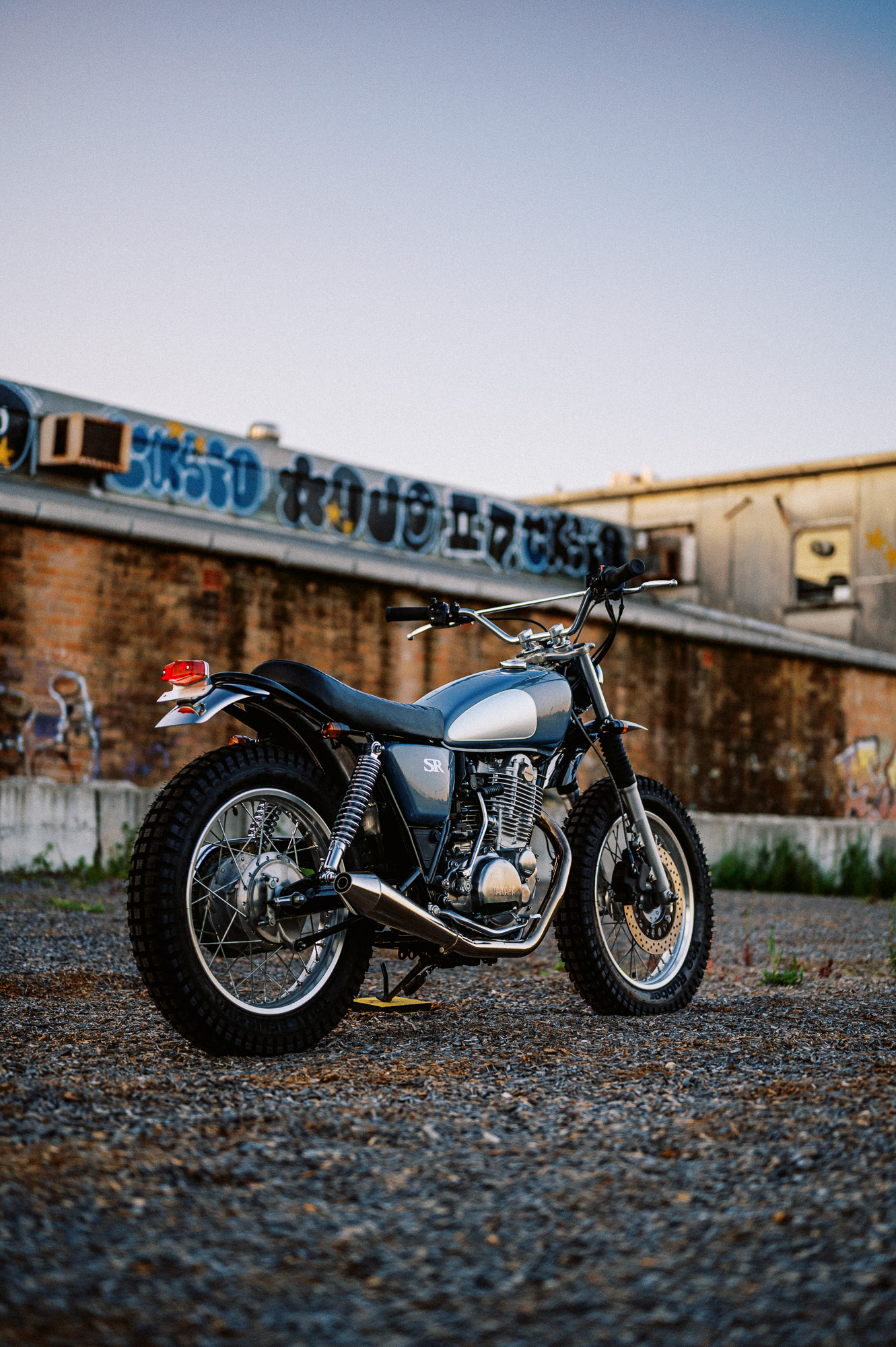 a custom Yamaha SR400 Motorcycle in Sydney at dusk in a vacant lot