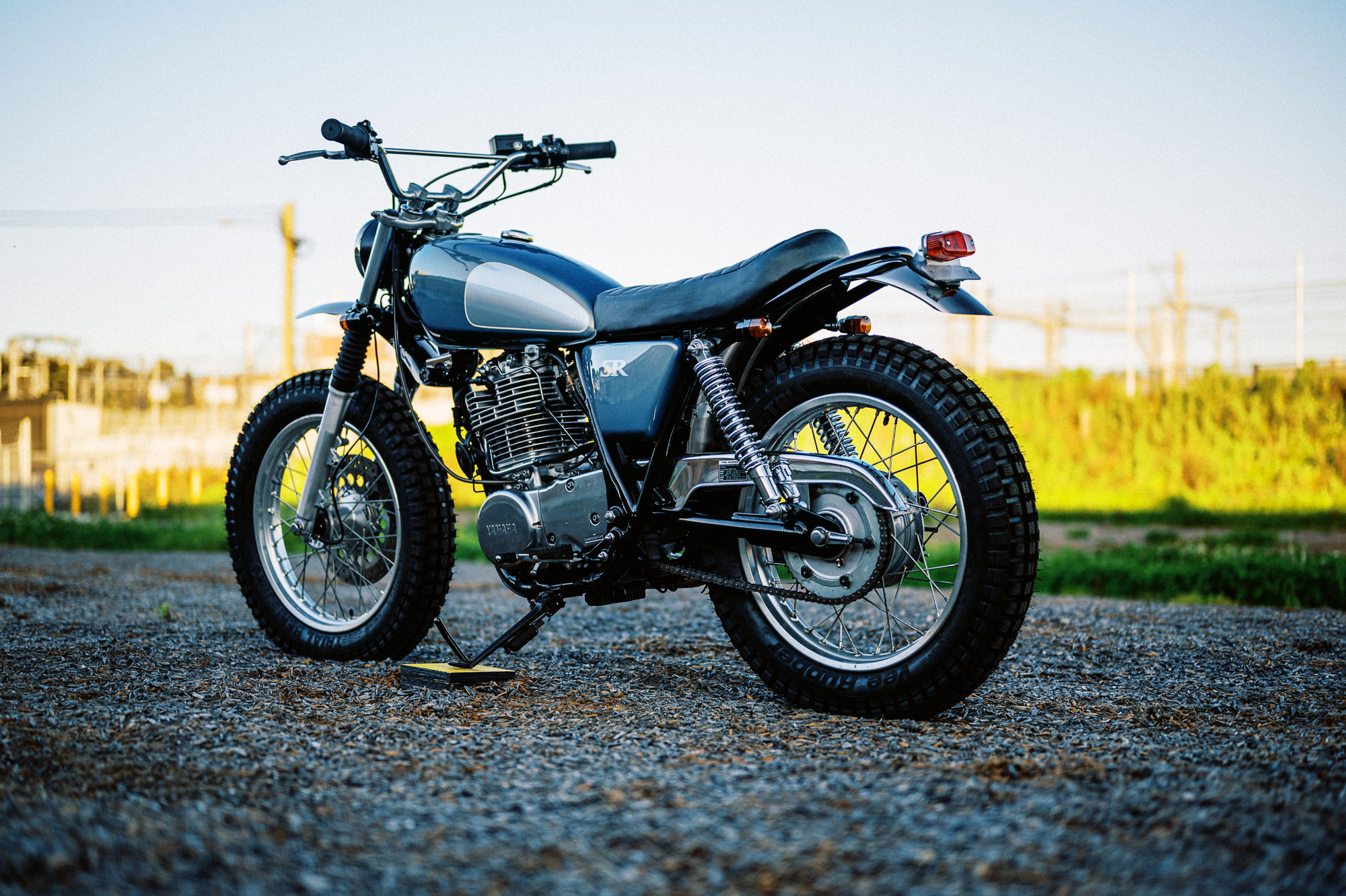 a custom Yamaha SR400 Motorcycle in Sydney at dusk in a vacant lot