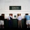 Four old men in front of six wagering windows.