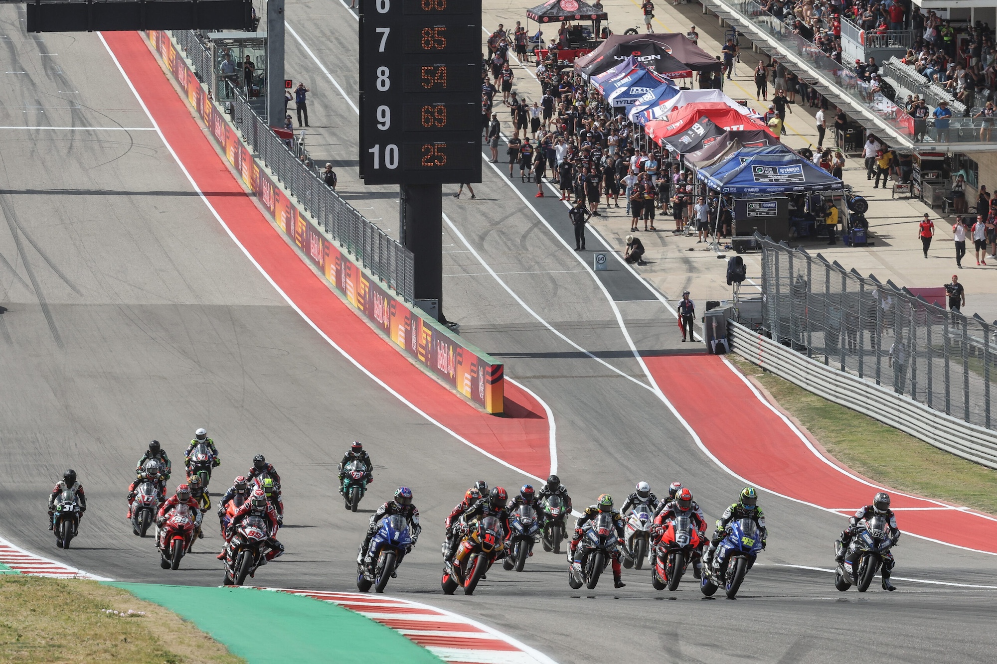 A group of motorcycle racers on a racetrack.