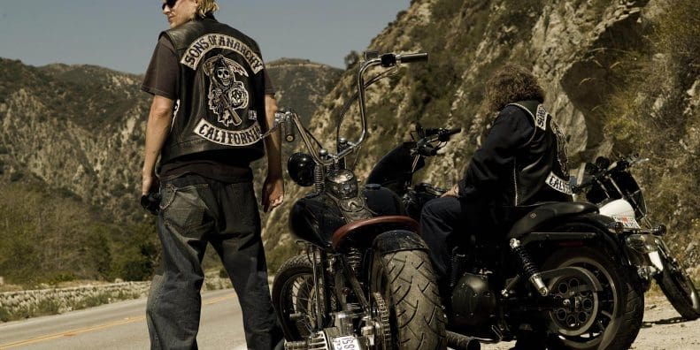 A motorcyclist standing next to two bikes. Media provided by Asphalt & Rubber.