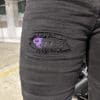Close up shot of RAVEN Logo on right thigh of the RAVEN High-Waisted REVOLT Ripped Armored Jeans