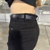 Ashley wearing a belt around waistband of the RAVEN High-Waisted REVOLT Ripped Armored Jeans