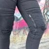 Close-up of RAVEN Women's High-Waisted REVOLT Ripped Armored Jeans showcasing knee zipper