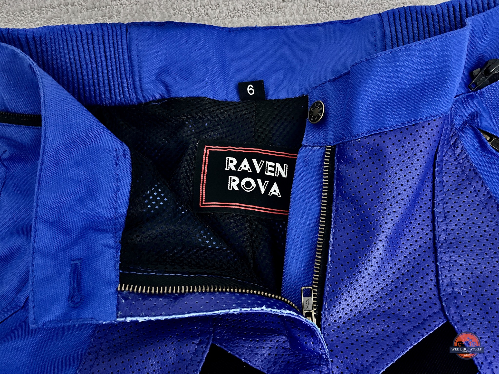 Closeup of the waist zipper and brand logo