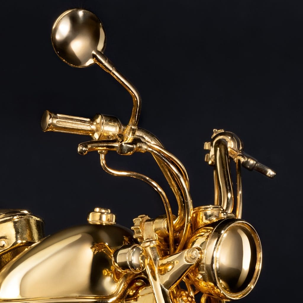 A gold motorcycle figurine's handlebars and mirrors.