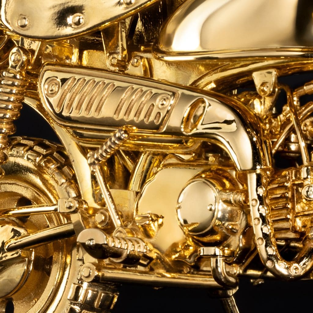 A gold motorcycle figurine's exhaust system.