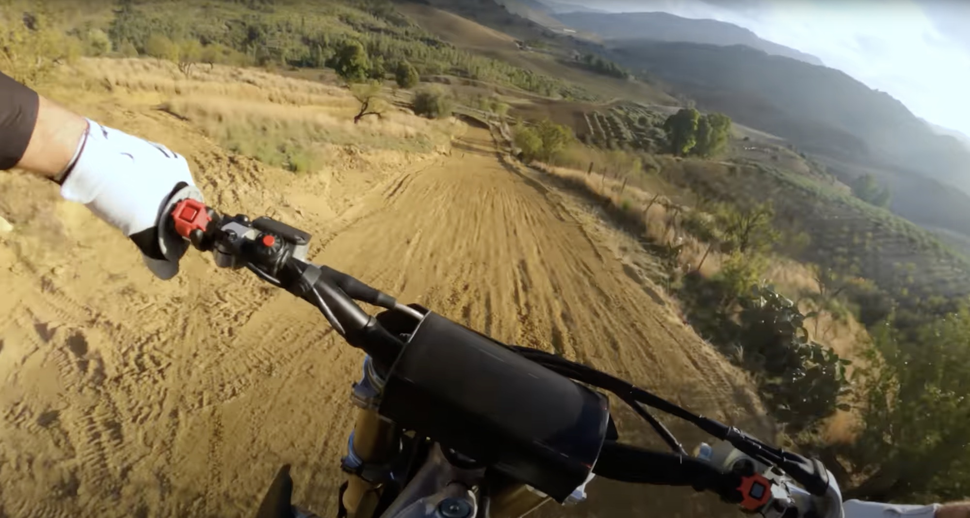 A view of a motocross motorcycle from behind the handlebars.
