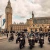 a group of motorcyclists in front of the London Parliament building.