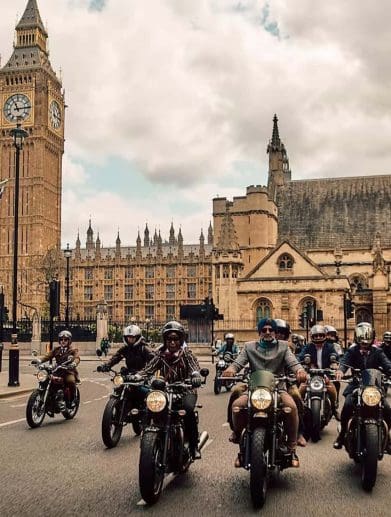 a group of motorcyclists in front of the London Parliament building.