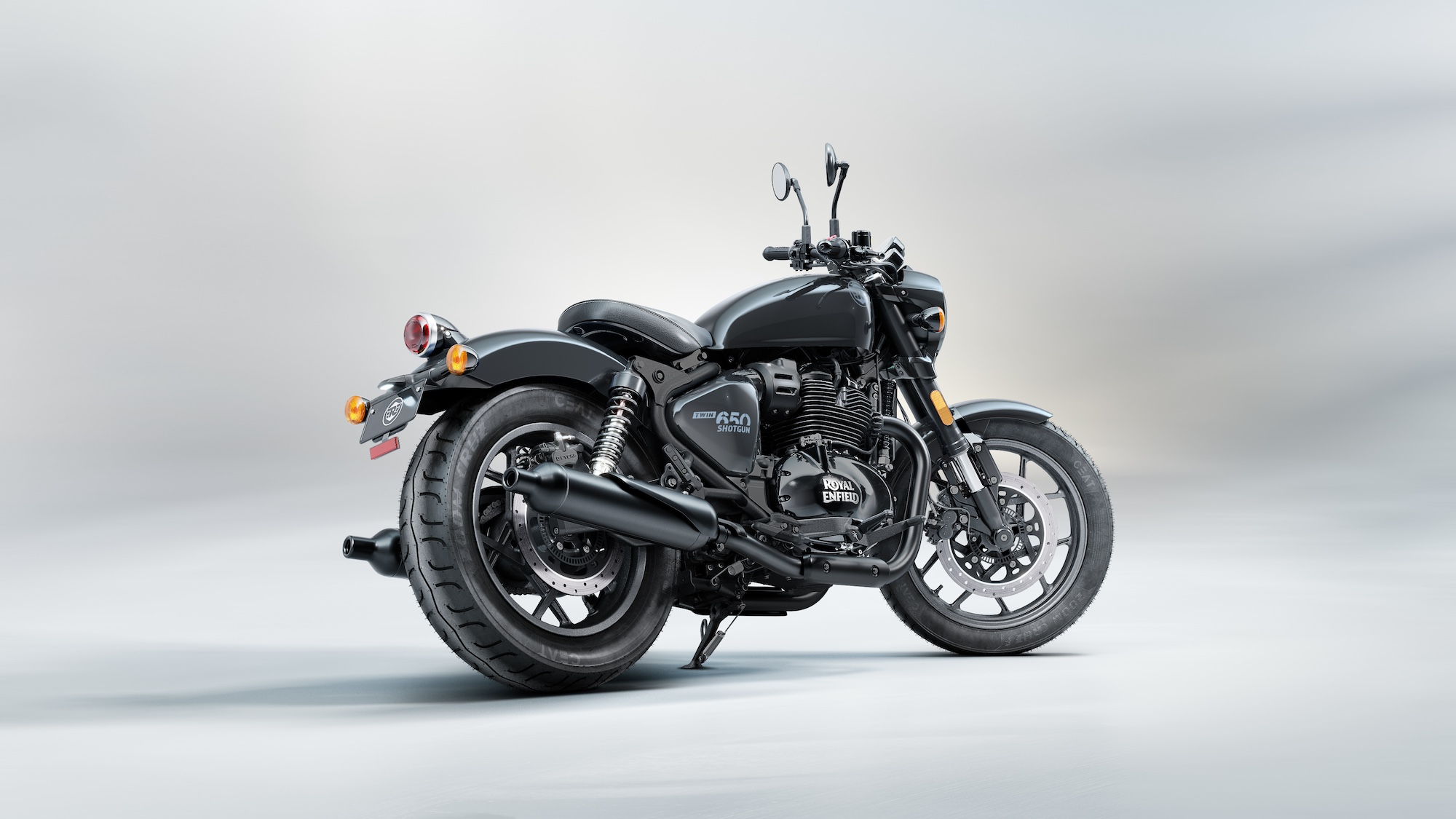 A rear quarter view of a Royal Enfield motorcycle in a studio setting.