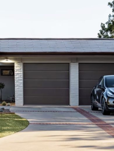 A house sporting a Tesla solar roof with a Tesla car parked in the driveway. Media provided by Tesla.
