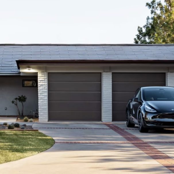 A house sporting a Tesla solar roof with a Tesla car parked in the driveway. Media provided by Tesla.