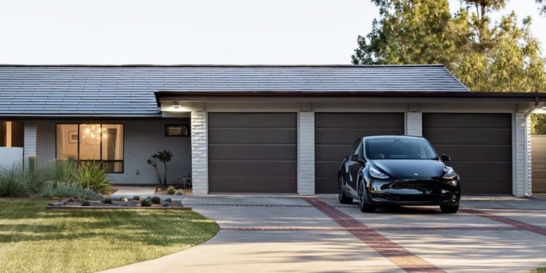 A house sporting a Tesla solar roof with a Tesla car parked in the driveway. Media provided by Tesla.