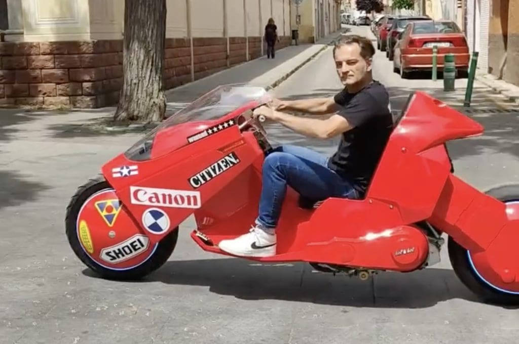 A side view of a man on a custom motorcycle.