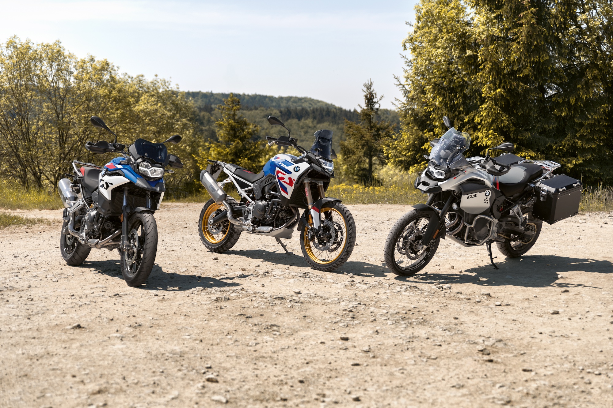 A view of three BMW motorcycles outside.