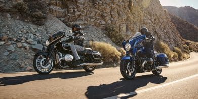 Two BMW motorcycles riding on a paved road.