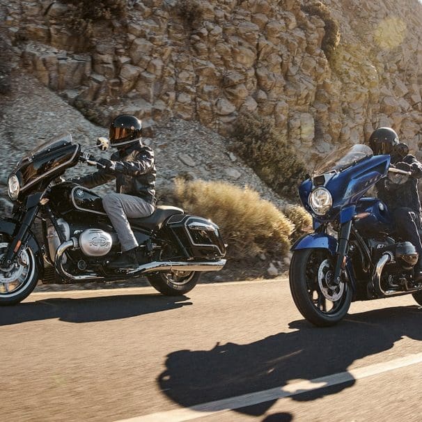 Two BMW motorcycles riding on a paved road.