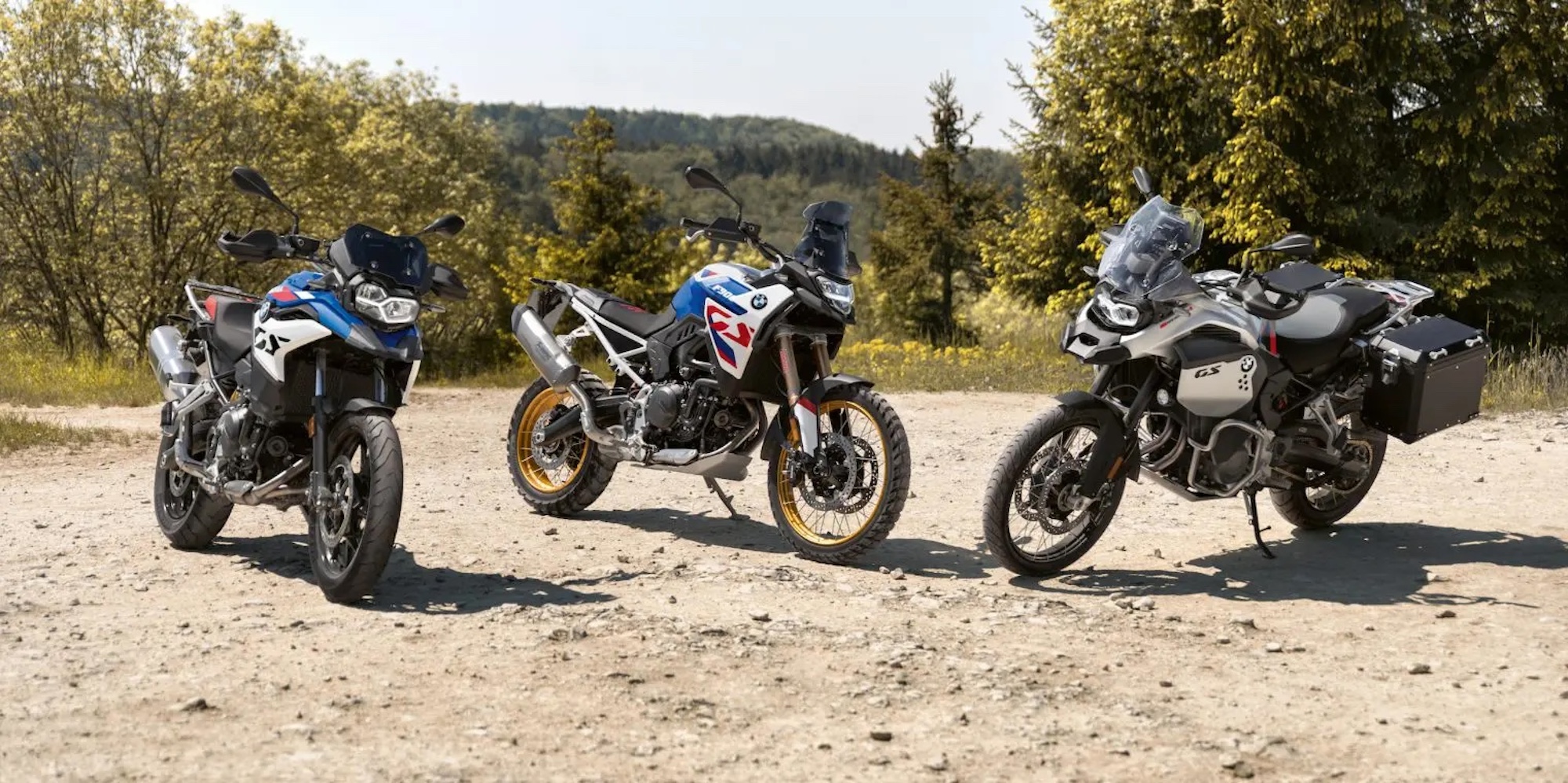 Three motorcycles on dirt. 